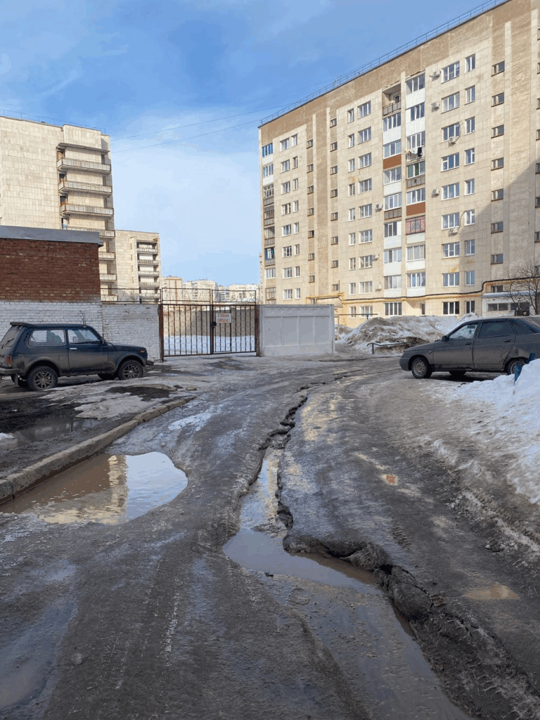 Октябрьский, ул. Новоселов, 18. Колея из льда. Нет нормальной возможности пройти, нет тротуара, не очищена дорога, скользко